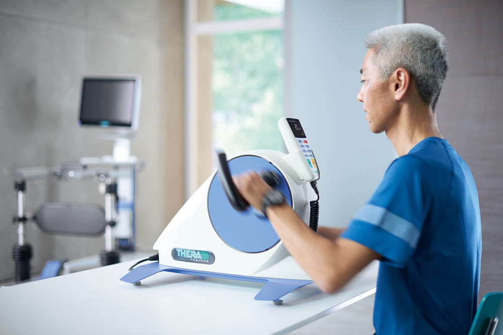 THERA-Trainer_Stimmungsbild_Therapieraum_mobi_Armtrainer Bein- und Oberkörpertrainer THERA-Trainer mobi 540
